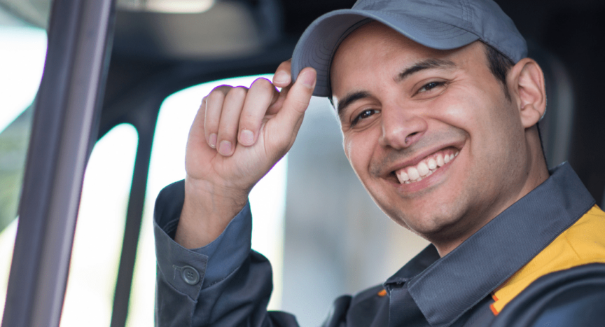 final mile driver smiling and tipping hat from behind the wheel