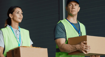 Man and woman wearing saftey vests and holding boxed packages